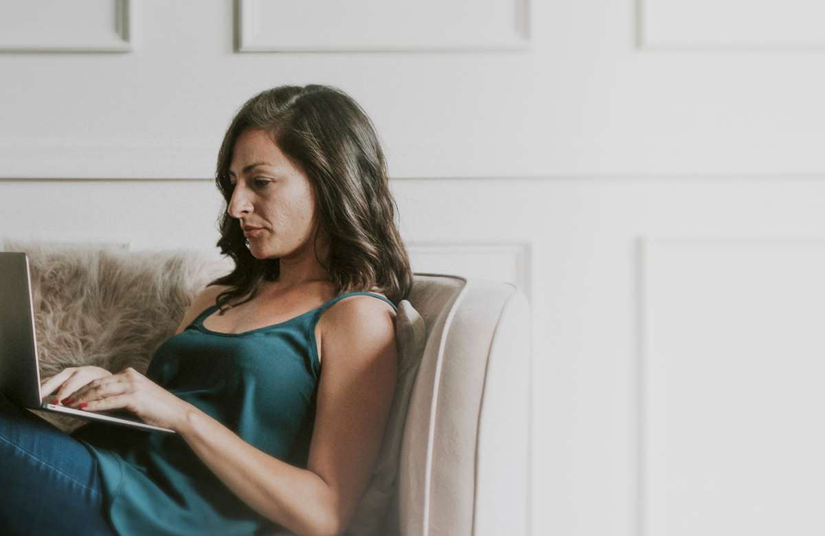 Woman sitting on a couch using a laptop