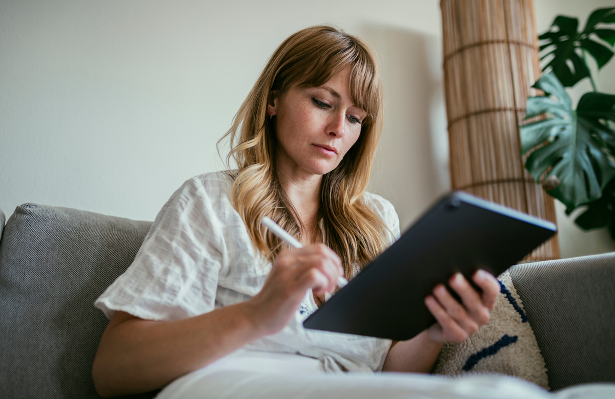 Woman sitting on a lounge using an iPad